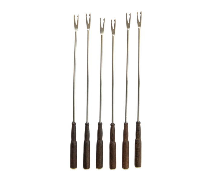 Set of six fondue forks with wooden handles on a white background