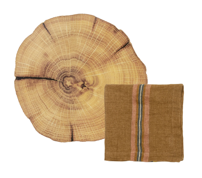 Folded brown napkin with striped pattern laid over a woodland placemat