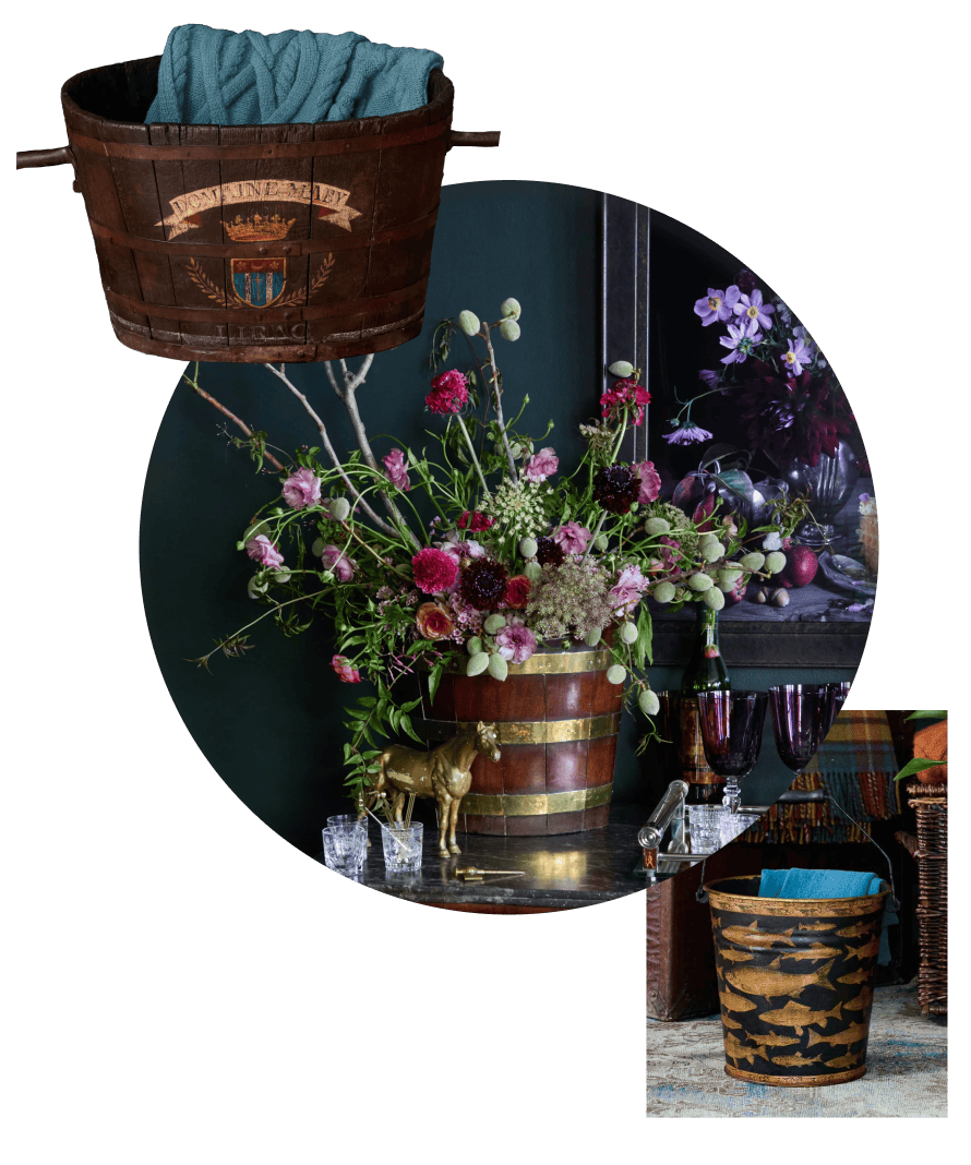 Decorative wooden barrels holding floral arrangements and blankets on a dark background.
