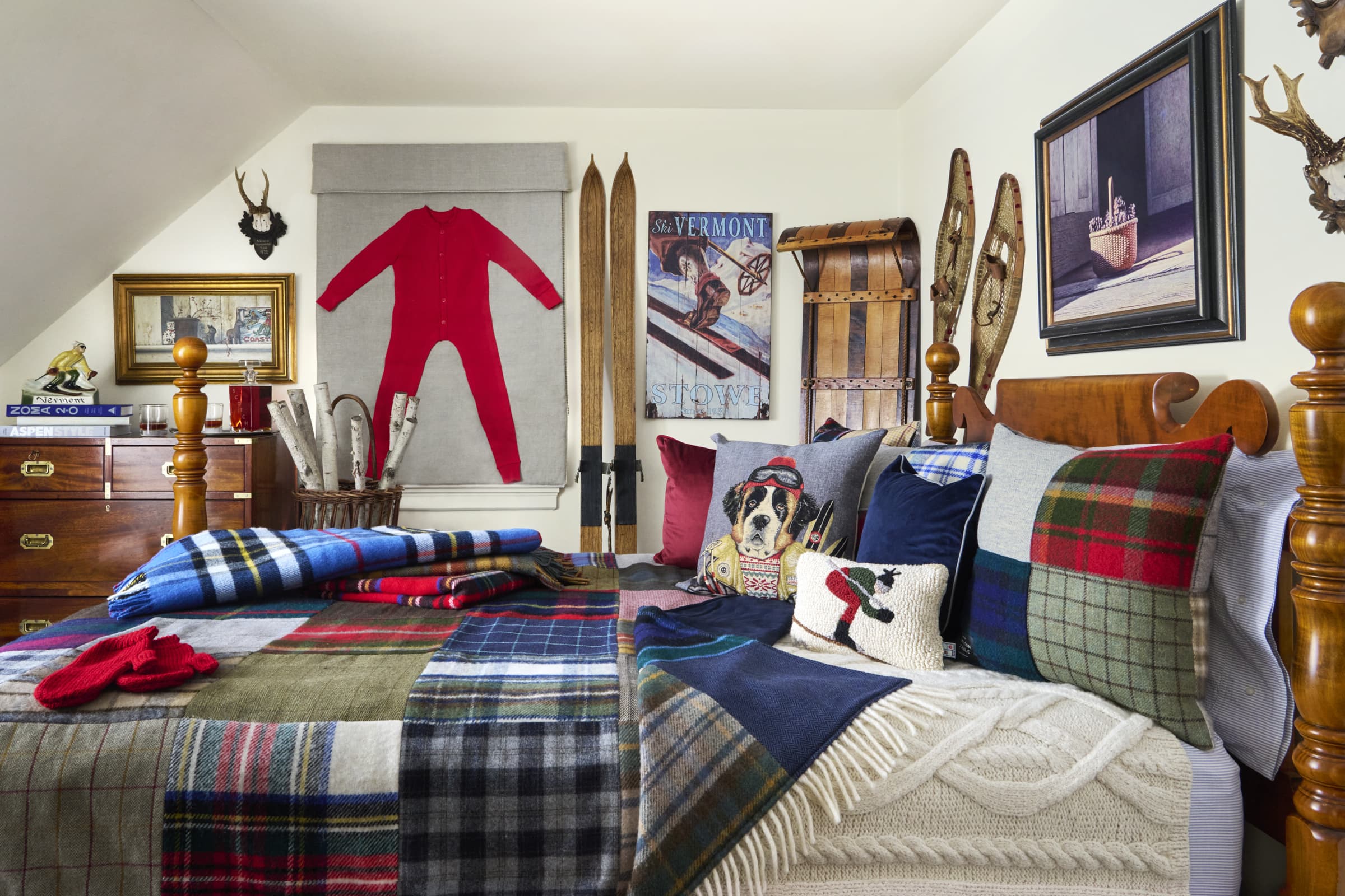 Bedroom with plaid bedding, ski-themed decorative pillows, and wall art.