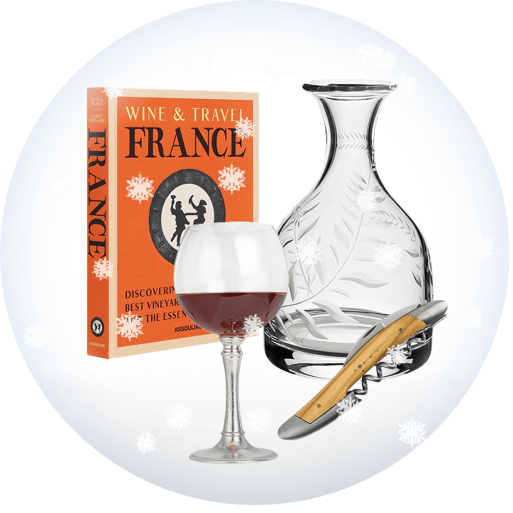 Wine glass, decanter, tool, and book titled 'Wine & Travel France' on a transparent background with snow.