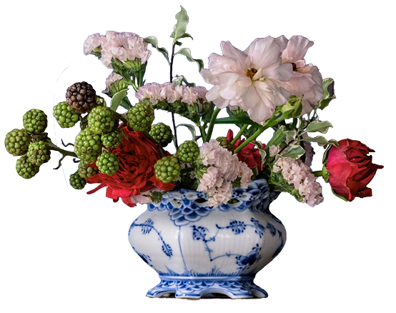 Floral arrangement in a blue and white ceramic sugar bowl on a white background