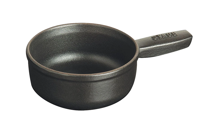 Black cast iron fondue pot with handle on a white background