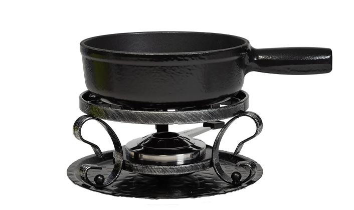 Black cast iron fondue pot on a matching stand with decorative elements on a white background