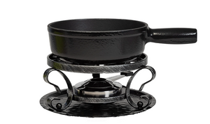  Black cast iron fondue pot on a matching stand with decorative elements on a white background 